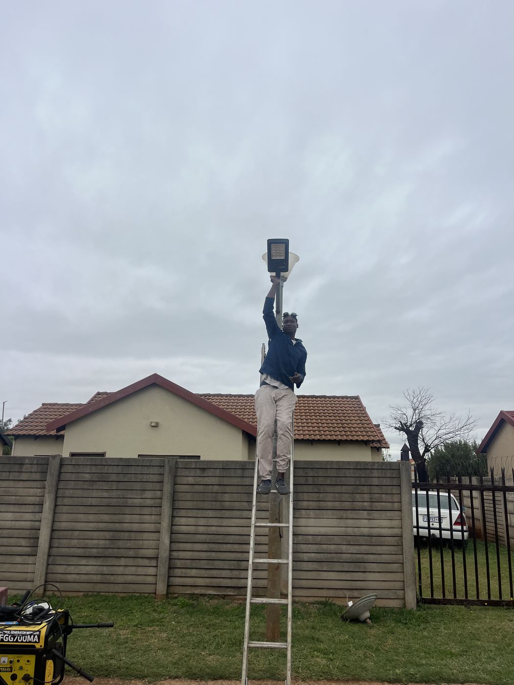Gebisa Projects technician installing an outdoor light fixture